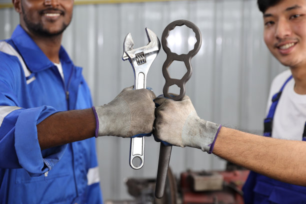 技师手握扳手和拳头在车库一起庆祝成功完成交易承诺。维护汽车和检查汽车零件的概念图片下载