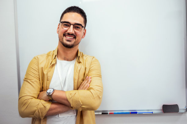 一位微笑的男教练在演讲厅里向观众展示的画像。图片下载