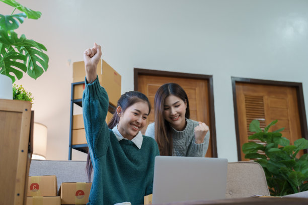 独立的亚洲女性创业企业家微笑着使用电脑笔记本电脑与愉快的成功的网络营销包装物品和中小企业配送概念图片下载