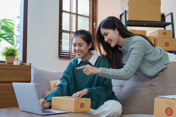 独立的亚洲女性创业企业家微笑着使用电脑笔记本电脑与愉快的成功的网络营销包装物品和中小企业配送概念图片下载