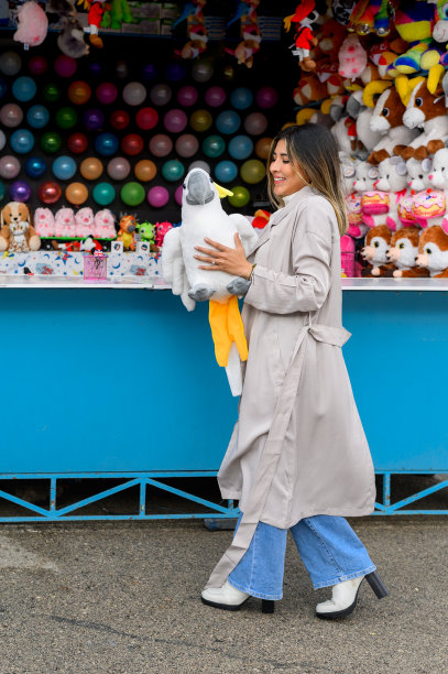 快乐的女人和毛绒玩具鹦鹉附近气球飞镖。图片下载