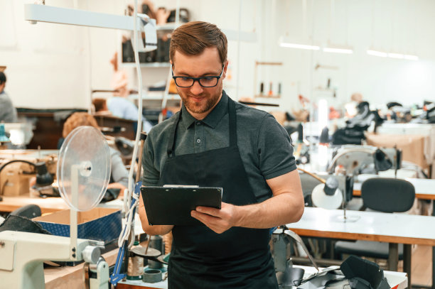 戴眼镜拿笔记本的人在房间里拿着缝纫机图片下载