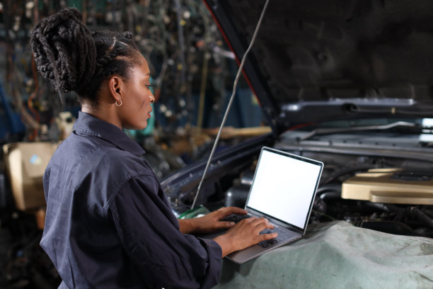 穿着制服的女技师在维修站用电脑检查汽车保养服务。汽车维修服务理念图片下载