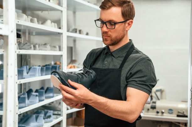 为鞋子寻找合适的尺码。男人在室内工作图片下载