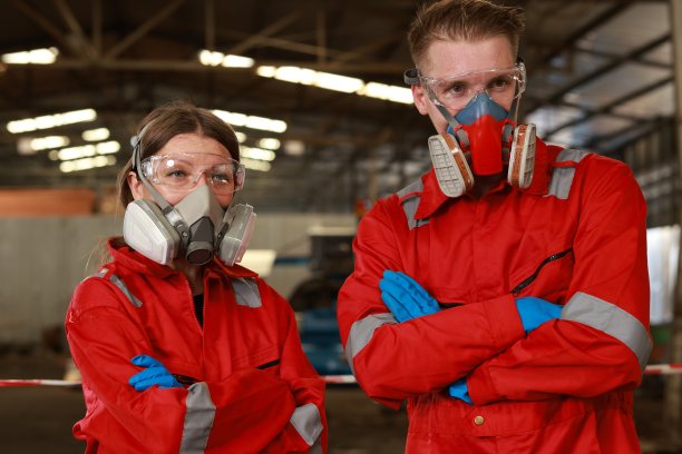 化学品泄漏和安全第一的理念。化工专家小组在工业工厂穿着安全制服，戴着防毒面具检查化学品泄漏。两位科学家正在检查植物中液体的质量图片下载