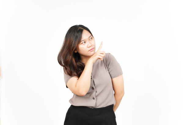 美丽的亚洲女人在白色隔离的展示产品和用食指指的一面图片下载