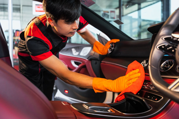 洗车车间工人吸尘，清洗汽车，清洗车内装饰，清洗汽车控制台。近距离对焦拍摄，图像的部分清晰度。图片下载