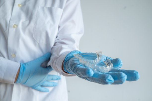 女医生拿着两个透明牙齿矫正器图片下载