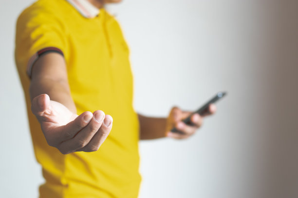 一个男性的手，用手机和智能手机，伸出手来图片下载