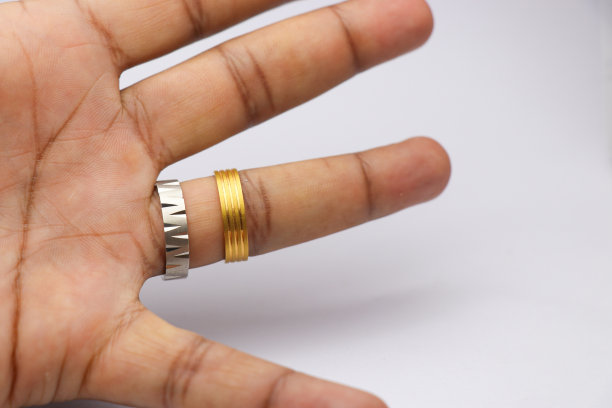 手指上戴着银戒指和金戒指。戴着金和银图片下载