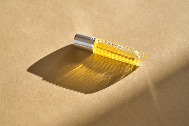 米色背景油辊香水。图片下载