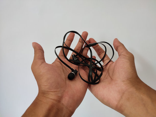 手持纠结的有线耳机在孤立的白色背景图片下载