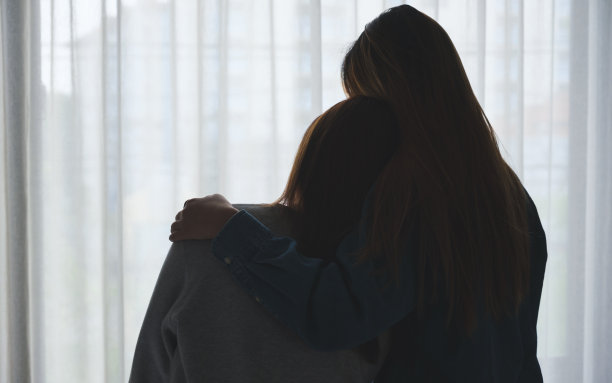 一个女人在卧室里拥抱她的朋友安慰和鼓励的剪影形象图片下载