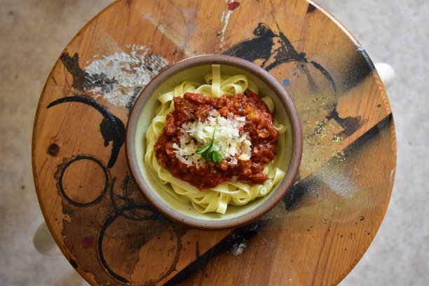 木桌上的碗里装着意大利肉酱面图片下载