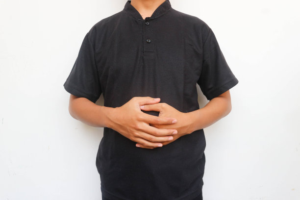 那个穿黑衬衫的男人捂着肚子站着图片下载