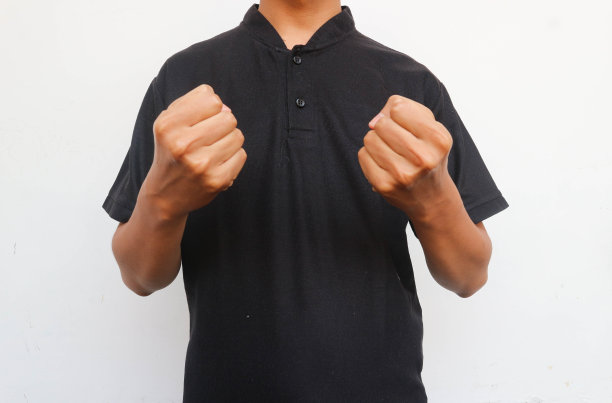 穿黑衬衫的人举起手来，露出紧握的拳头图片下载