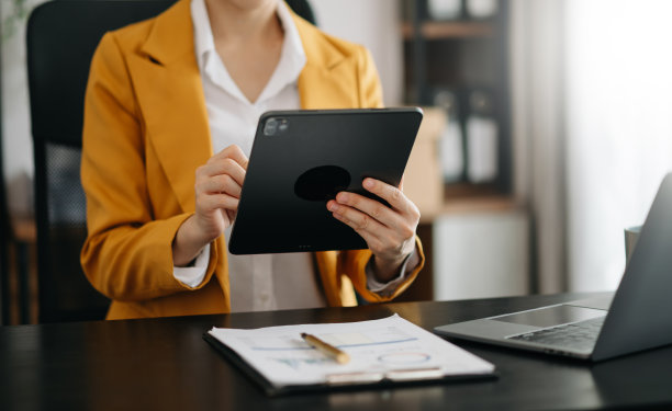 在晨光中，女商人用智能手机、笔记本电脑和平板电脑，桌上放着社交网络图作为概念。图片下载