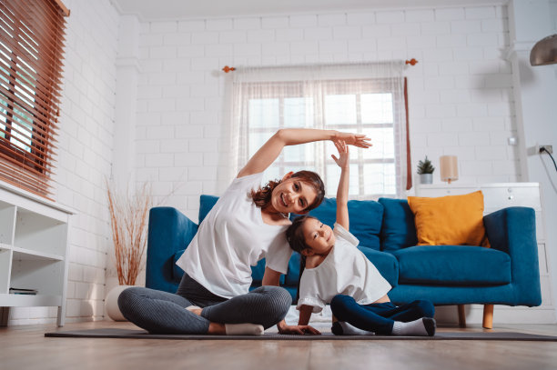 母女俩在家里愉快地一起运动。为柔韧性增强肌肉力量，运动锻炼全家一起训练的理念。图片下载
