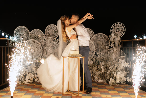 新婚夫妇高兴地切蛋糕，品尝婚礼蛋糕图片下载