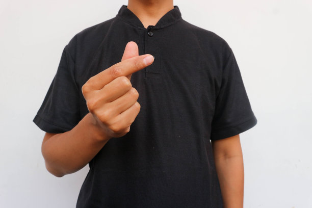 穿黑衬衫的男子举起手，表示爱的手势或韩国的爱的手势。Saranghae图片下载