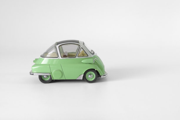 给孩子们的旧的绿色玩具车。有时间和磨损的痕迹。孤立在浅灰色的背景上。图片下载