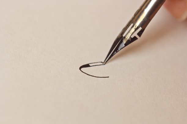 手用墨笔在有条纹的白纸上写字。办公桌上的文具近距离俯视图。拼写课和书法练习。模板，布局，背景。宏图片下载