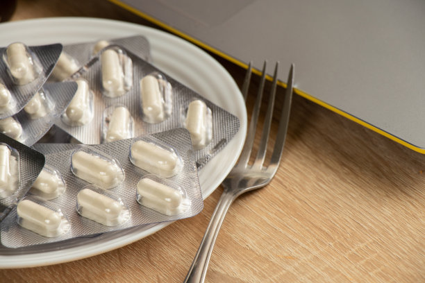 午餐时，桌上的白色盘子里装着白色药片图片下载
