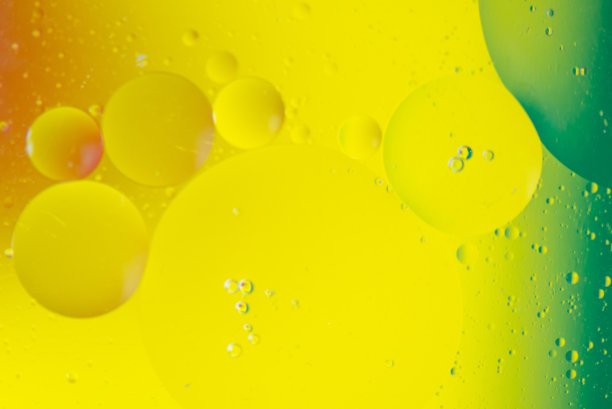 特写的油泡沫和滴在彩色水的背景图片下载