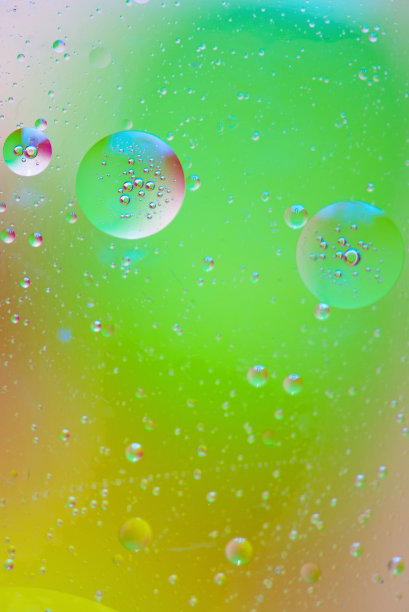 特写的油泡沫和滴在彩色水的背景图片下载