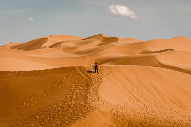 一名妇女在库姆塔格沙漠的沙丘上徒步旅行图片下载