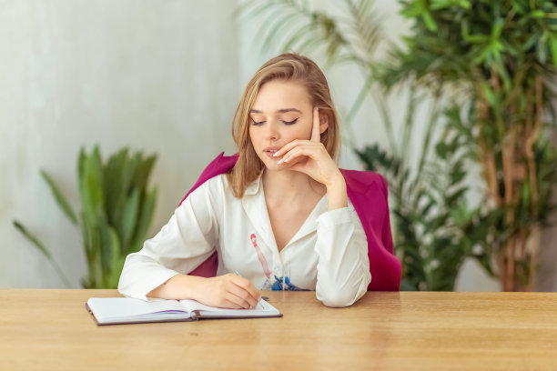 年轻漂亮的大学生女孩学习，忙着大学考试，担心，绝望和压力，感到疲倦和考试的压力，坐在桌子上与书在青年教育理念图片下载