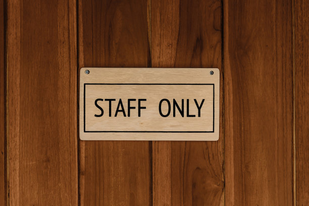员工只有木文本徽章标志横幅在木制门板背景。图片下载