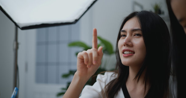 年轻美丽的亚洲女人在服装店直播图片下载