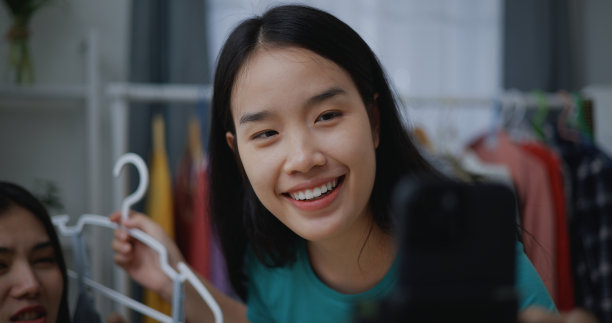 年轻的亚洲女时装设计师用手机直播图片下载