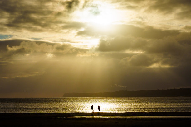 沙滩上夕阳下的情侣图片下载