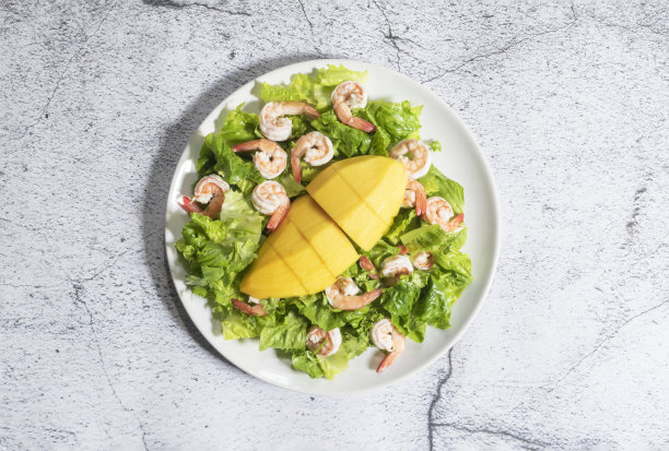 健康食品虾沙拉有芒果长叶莴苣碗有海鲜酱石板背景。图片下载