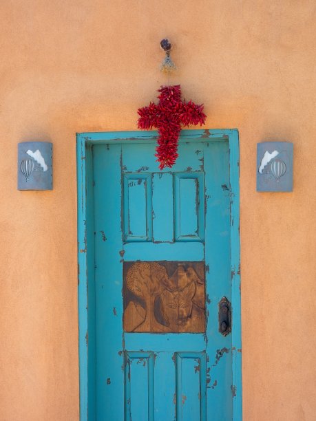 土坯房屋上的绿松石门道和红辣椒做成的宗教十字架图片下载