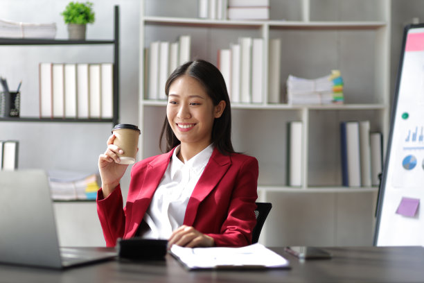 女商人在办公室桌子上用笔记本电脑处理文件。图片下载