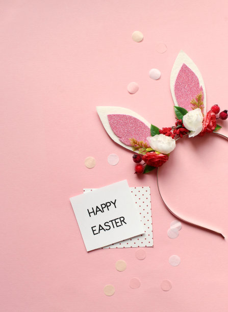 复活节派对的概念。复活节兔子耳朵的俯视图照片，白色，粉红色，蓝色和黄色的蛋在孤立的淡蓝色背景与中间的copyspace图片下载