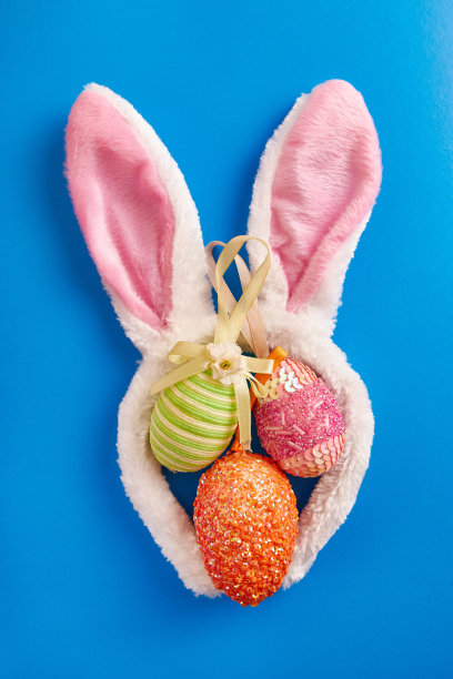 蓝色背景上的兔子耳朵和复活节彩蛋。复活节庆祝活动。图片下载