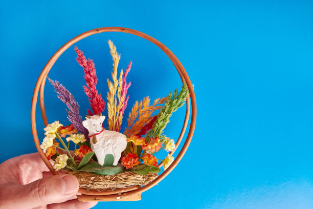 复活节构图与公羊，草和木基础上的蓝色背景。复活节庆祝活动。复活节的背景。图片下载