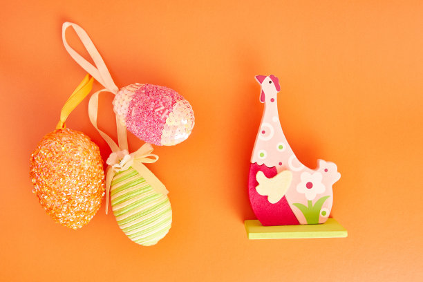 橙色背景上的鸡和蛋的复活节构图。复活节庆祝活动。图片下载