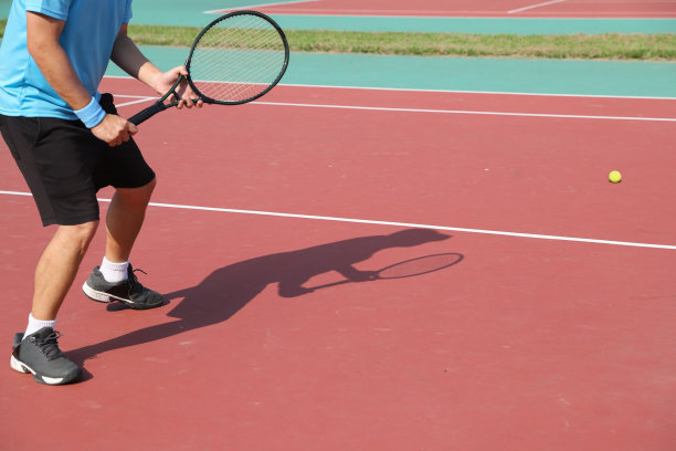 网球运动员的影子投射在网球上图片下载
