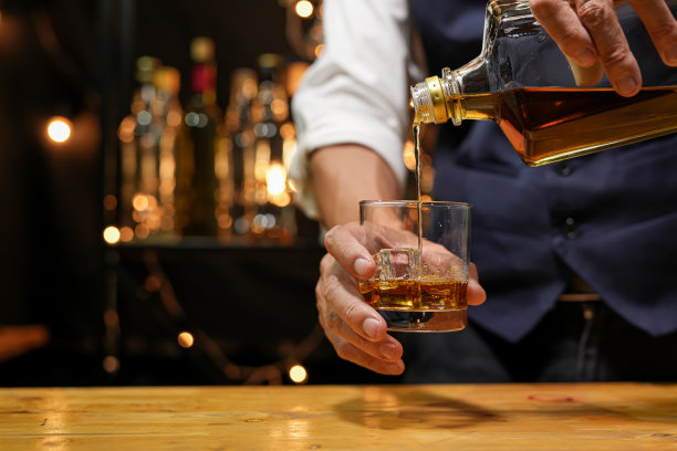 调酒师在吧台上倒威士忌，图片下载