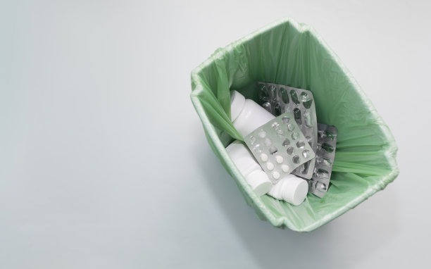 模拟垃圾桶，桶满的药物，补充。采购产品药丸，片剂瓶，空胶囊。医疗废物，药品消费观念。药店水平平面复制空间，俯视图。图片下载