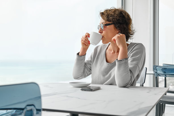 清晨，自由职业的女商人独自在咖啡馆里享受着香气四溢的咖啡。图片下载