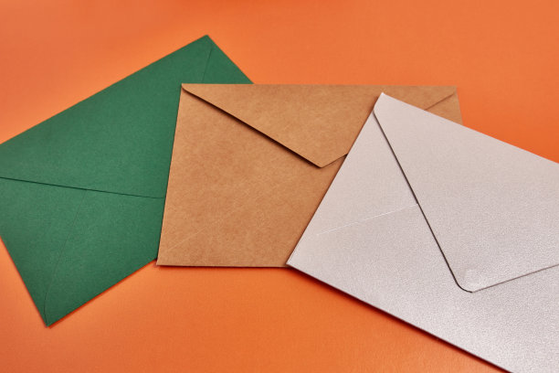 橙色背景上的彩色纸板信封。图片下载