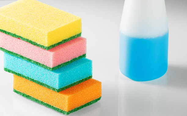 家庭清洁用品。瓶子与洗涤剂和多色海绵在白色的背景图片下载