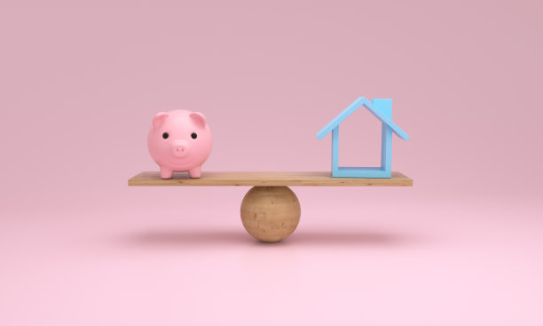 房子和小猪储蓄罐在跷跷板上保持平衡。图片下载