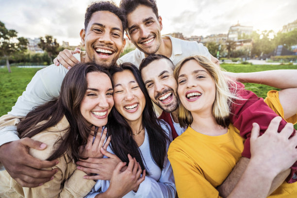多元文化的年轻人在户外对着镜头微笑，快乐的朋友在一起玩耍，大学生站在大学校园里图片下载